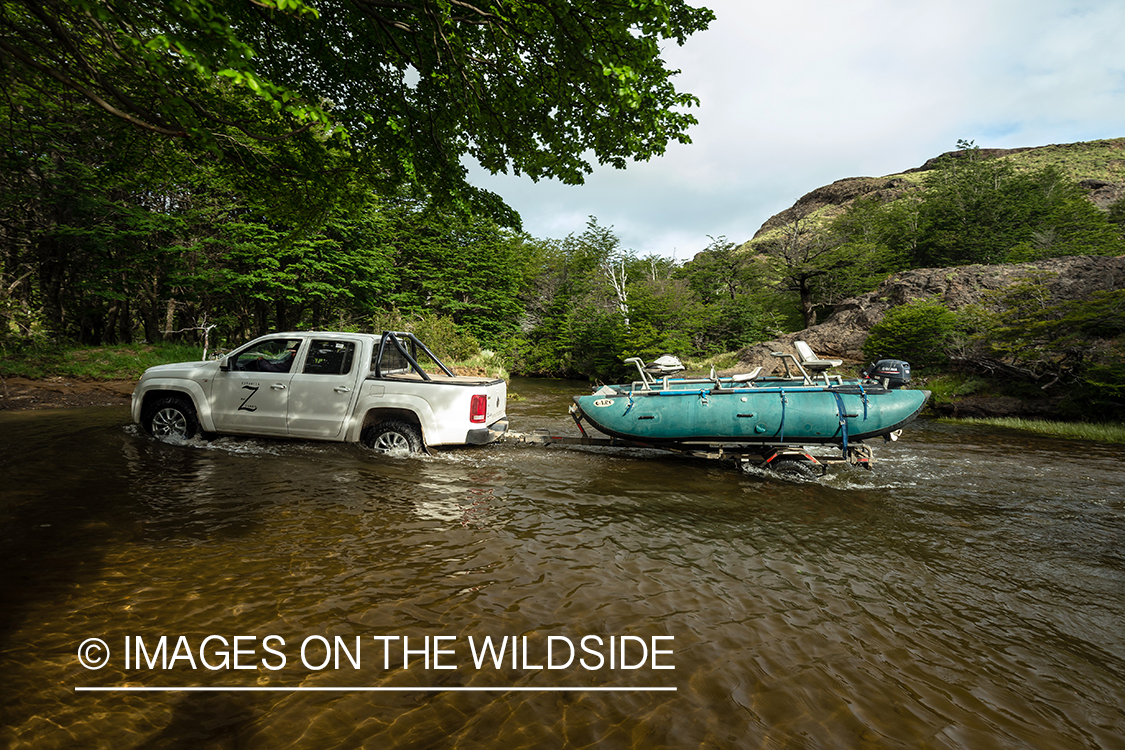 Crossing stream with truck and trailer.