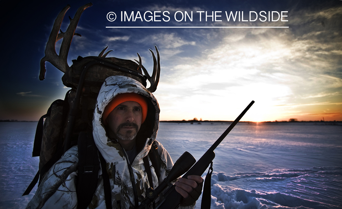 Hunter with bagged white-tailed deer in winter.