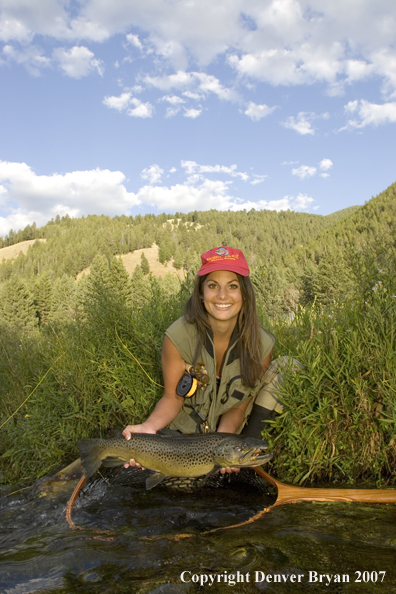 Woman flyfisher with large brown trout.