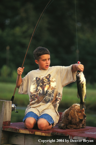 Boy holding large-mouth bass.