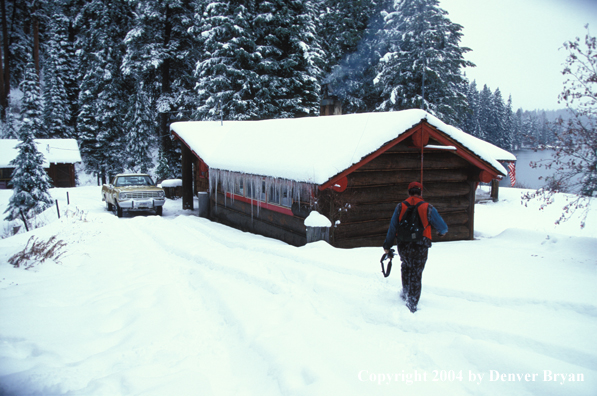 Big game hunter walking towards cabin.