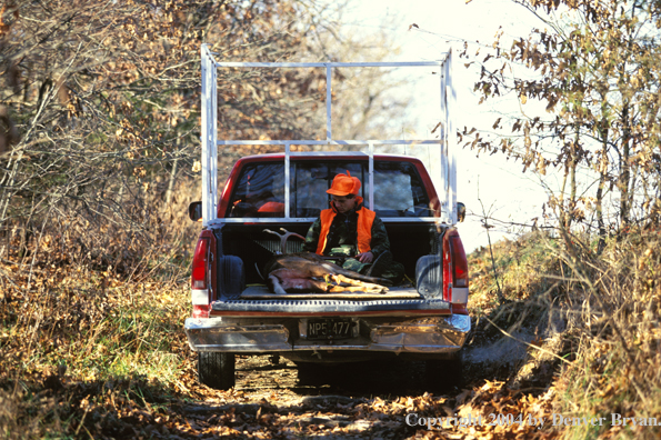 Father and son driving away with white-tailed deer.