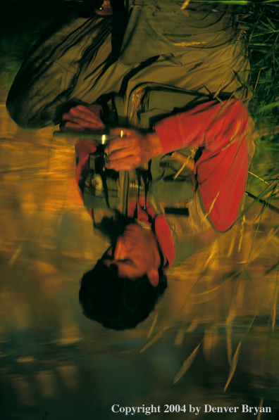 Reflection of flyfisherman choosing flies.