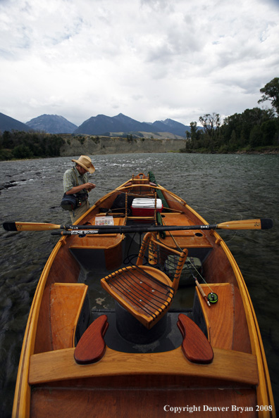 Flyfisherman with drift boat in forefront.