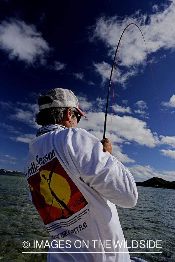 Saltwater flyfisherman fishing on flats boat, in Hawaii. 