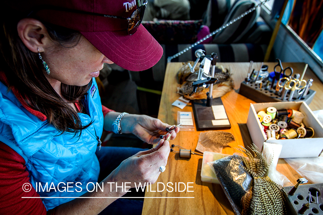 Woman flyfisher tying flies.