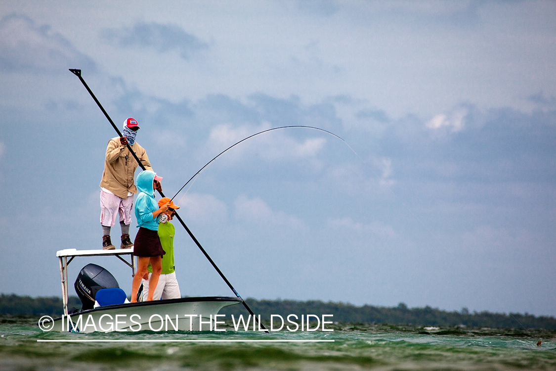 Flyfishing woman on flats boat with guide.