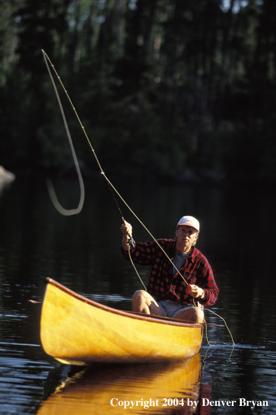 Flyfisherman fishing from cedar canoe.