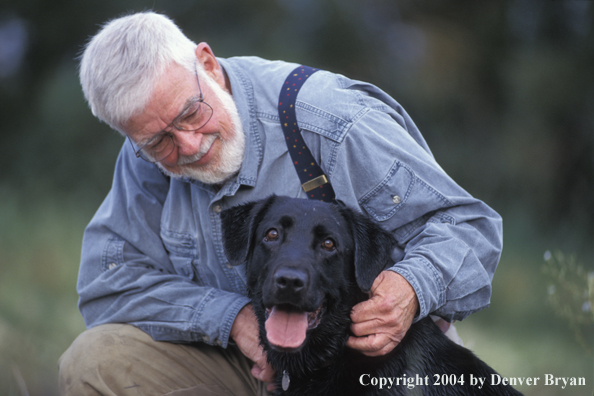 Owner petting Black Labrador Retriever 