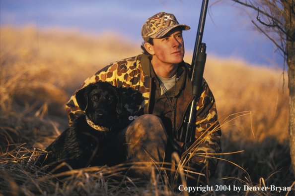 Waterfowl hunter with black Lab. 