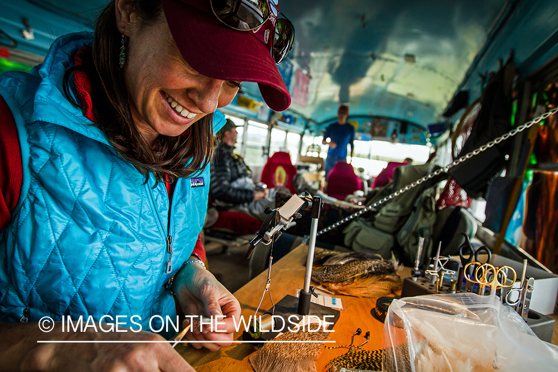 Woman flyfisher tying flies.