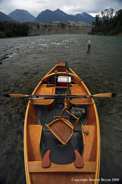 Flyfisherman with drift boat in forefront.