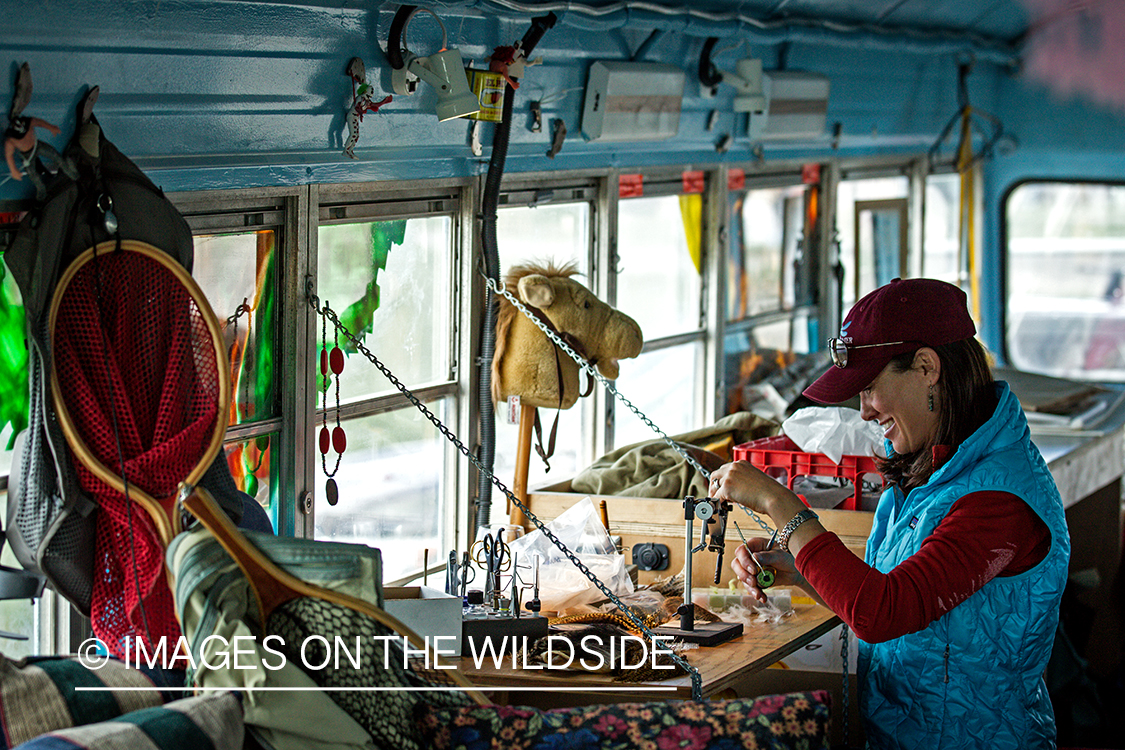 Woman flyfisher tying flies.