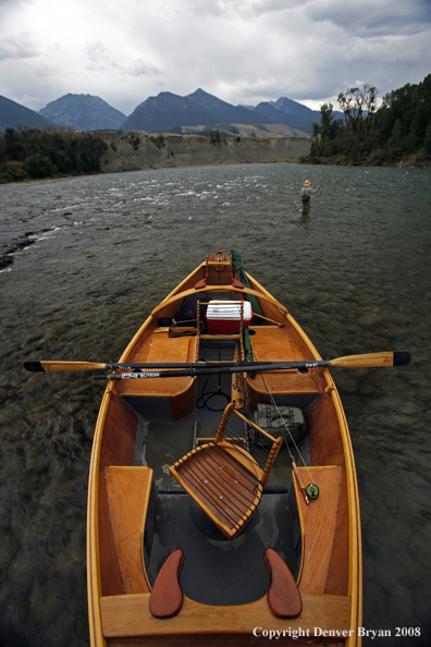 Flyfisherman with drift boat in forefront.