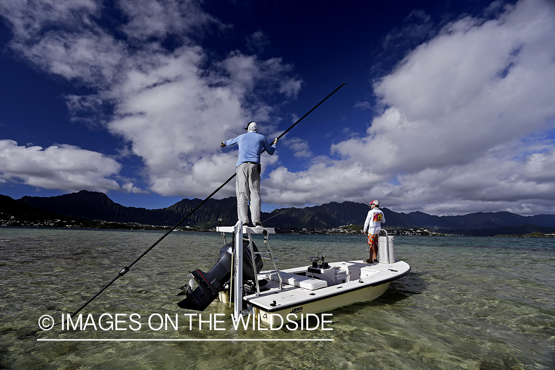 Saltwater flyfishermen fishing on flats boat, in Hawaii.