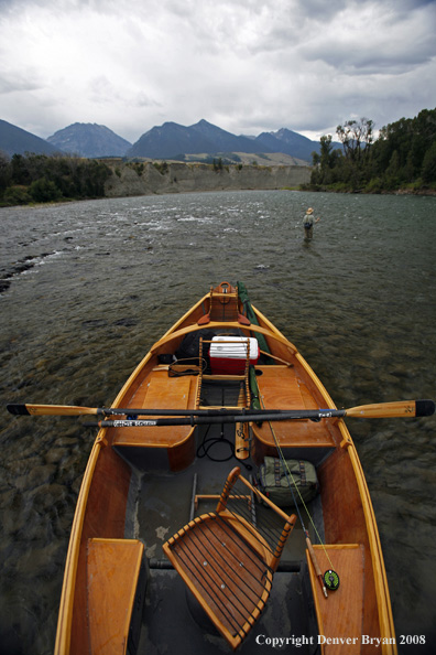 Flyfisherman with drift boat in forefront.