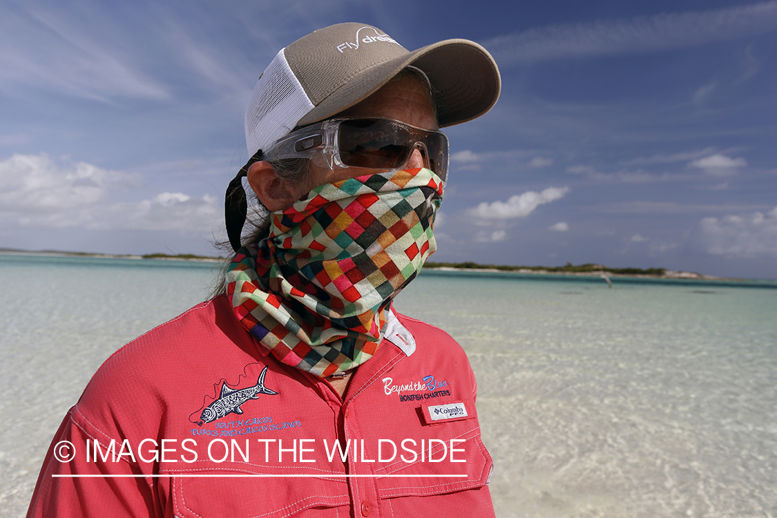 Saltwater flyfishing woman looking for fish in flats.