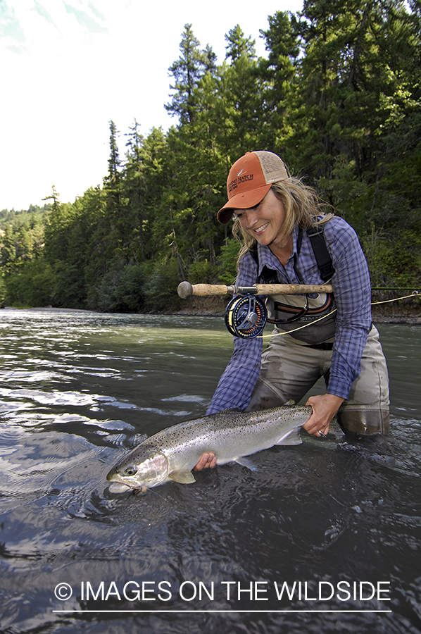 Woman flyfisher with steelhead catch. 