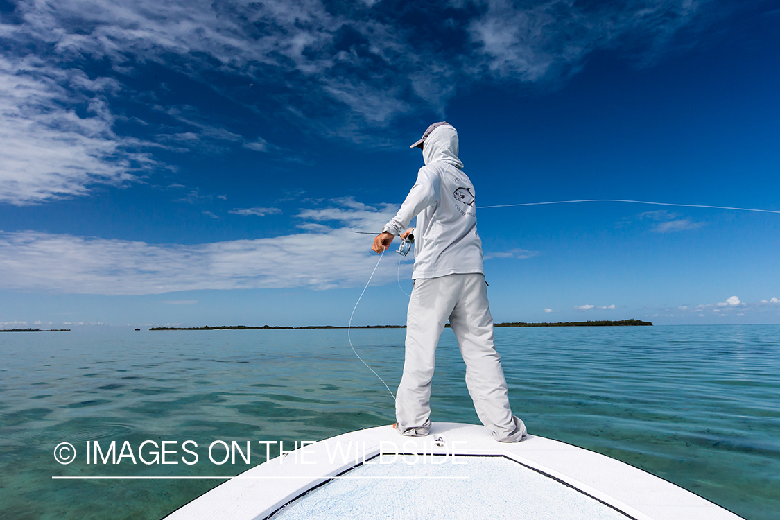 Flyfisherman casting line on flats boat.