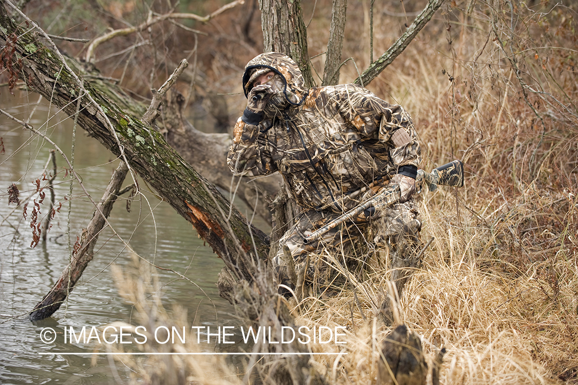 Waterfowl hunter waterfowl calling in wetlands.