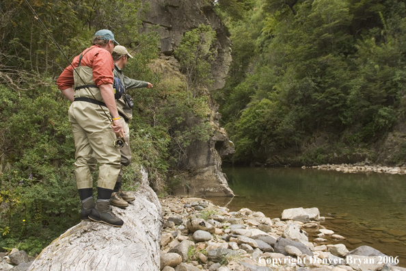 Flyfishermen scanning river for fish.