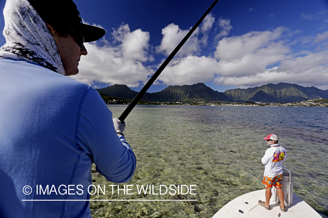 Saltwater flyfishermen fishing on flats boat, in Hawaii.