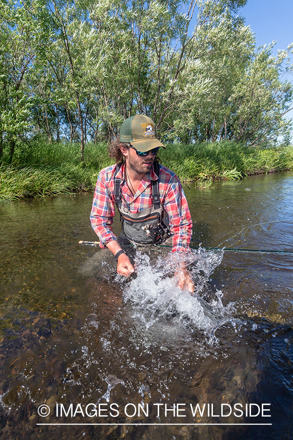 Flyfisherman fighting fish on the Sedanka river in Kamchatka Peninsula, Russia. 