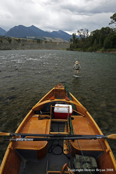 Flyfisherman with drift boat in forefront.