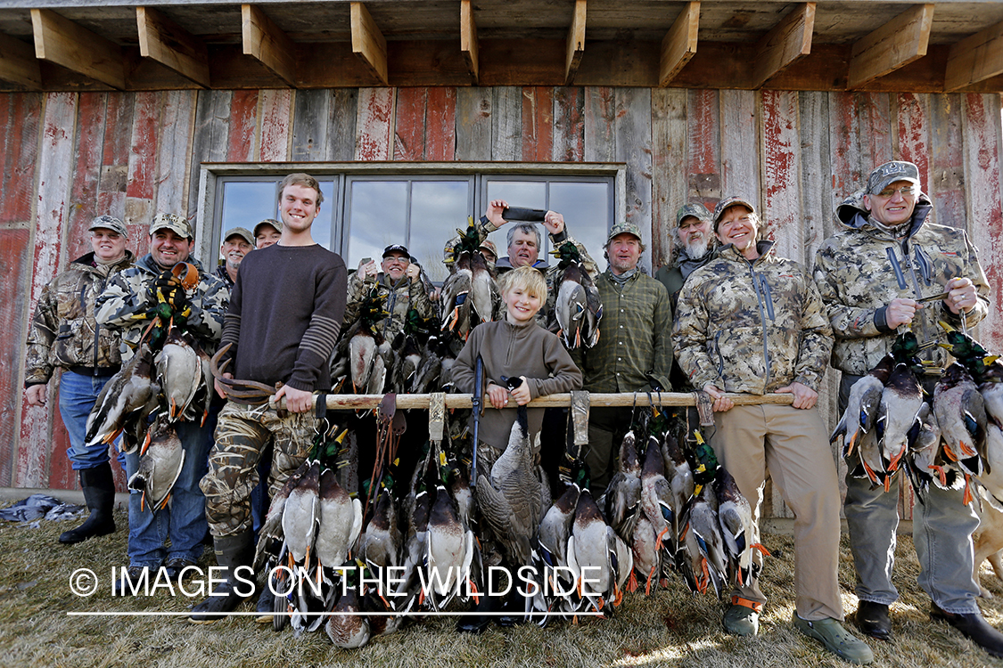 Group of waterfowl hunters with bagged ducks.