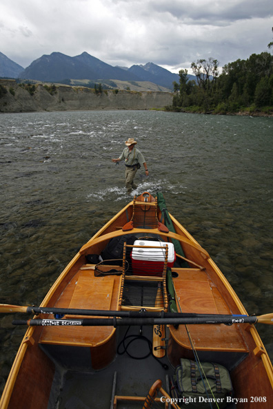 Flyfisherman with drift boat in forefront.