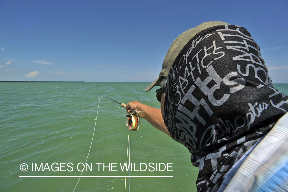 Saltwater flyfisherman casting on flats boat.