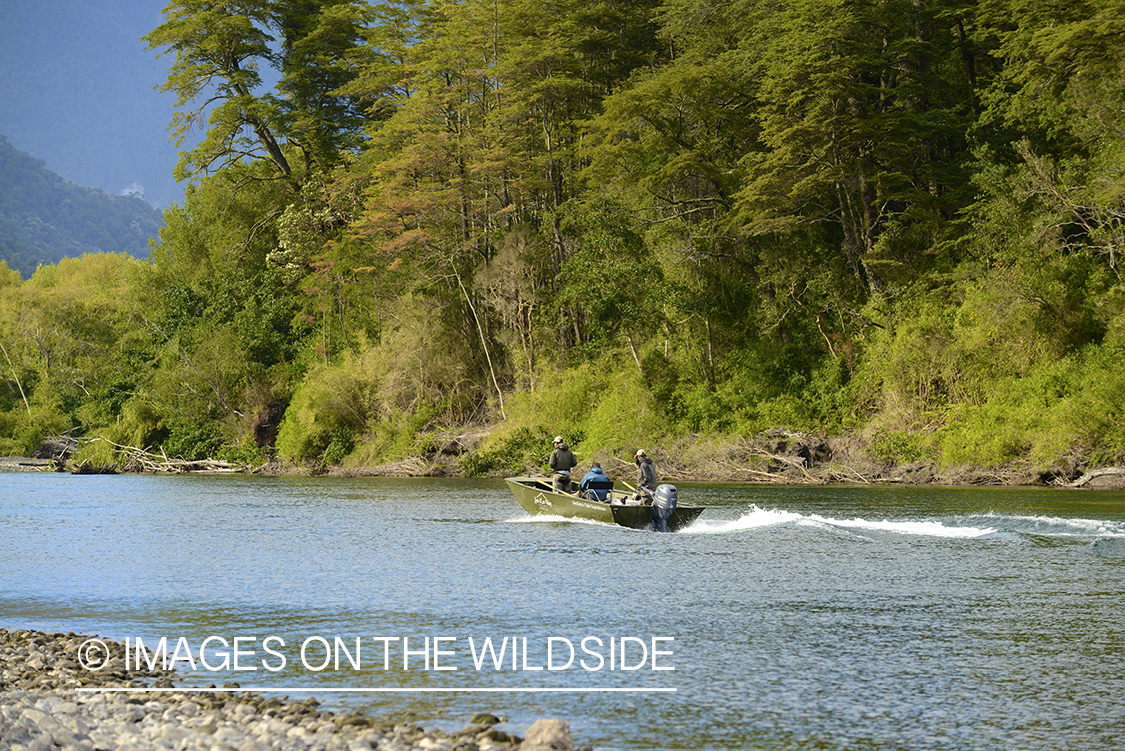 Fishermen on boat in river in Chile.