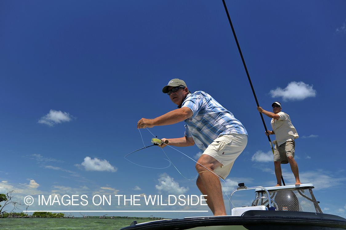 Saltwater flyfisherman casting on flats boat.