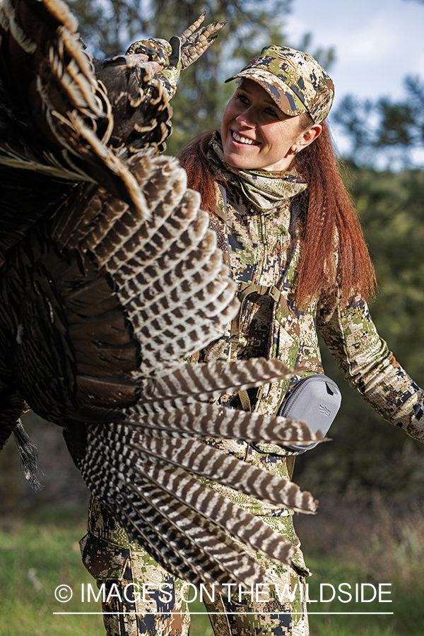 Women hunter with bagged turkey.