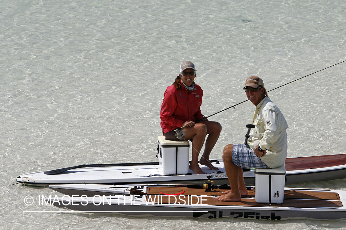 Saltwater flyfishing couple on paddle boards.