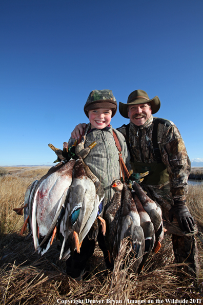 Father and son with bagged mallards. 