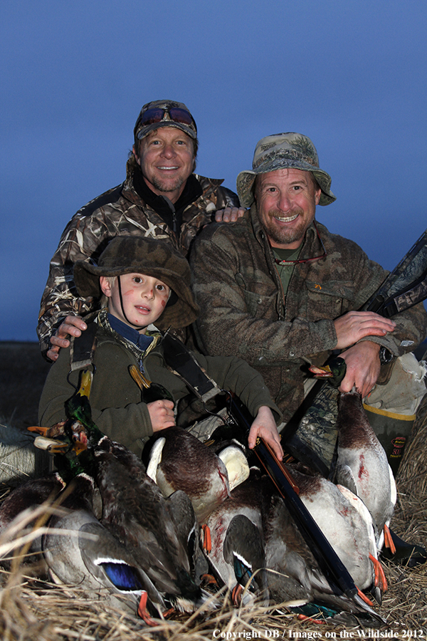 Experienced hunters and young hunter with bagged waterfowl.