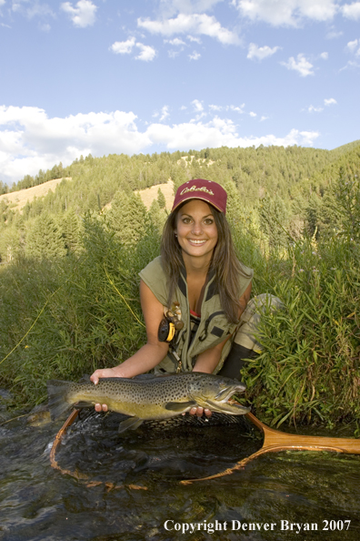 Woman flyfisher with large brown trout.