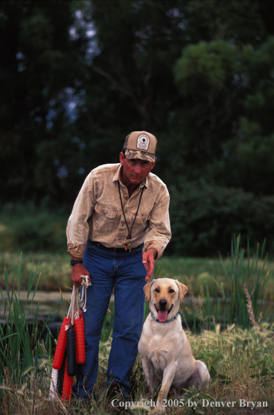 Trainer with yellow Labrador Retriever.