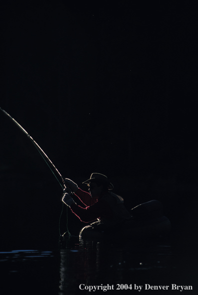 Flyfisherman casting from float tube at night.