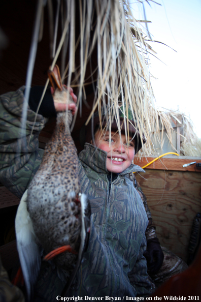 Child with bagged mallard. 