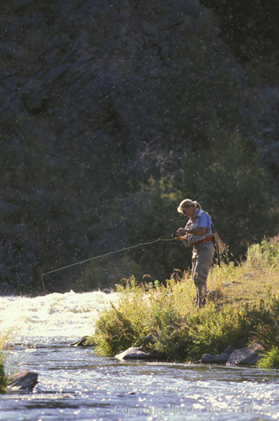 Woman flyfishing tying a fly. 