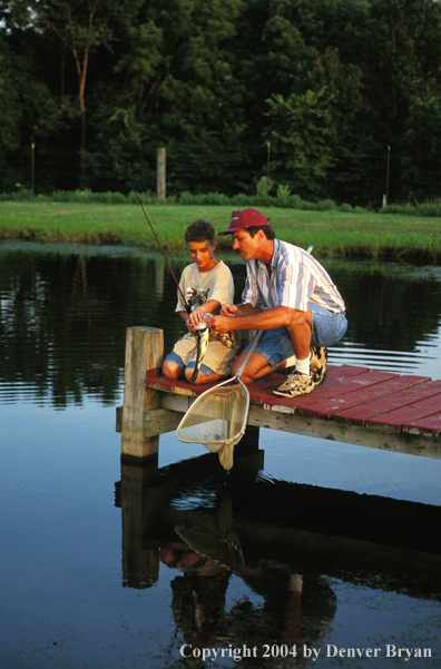 Man helping boy with fish.