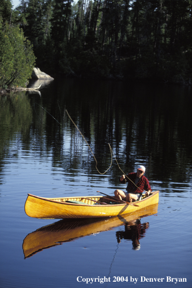 Flyfisherman fishing from cedar canoe.