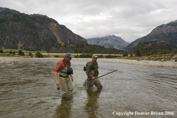 Flyfishermen crossing river.