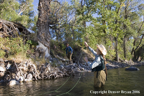 Woman flyfisher and flyfisherman undoing a snag.