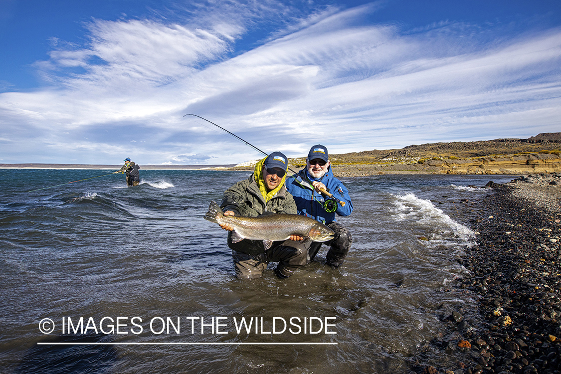 Flyfisherman with large rainbow trout at Jurassic Lake, Argentina.