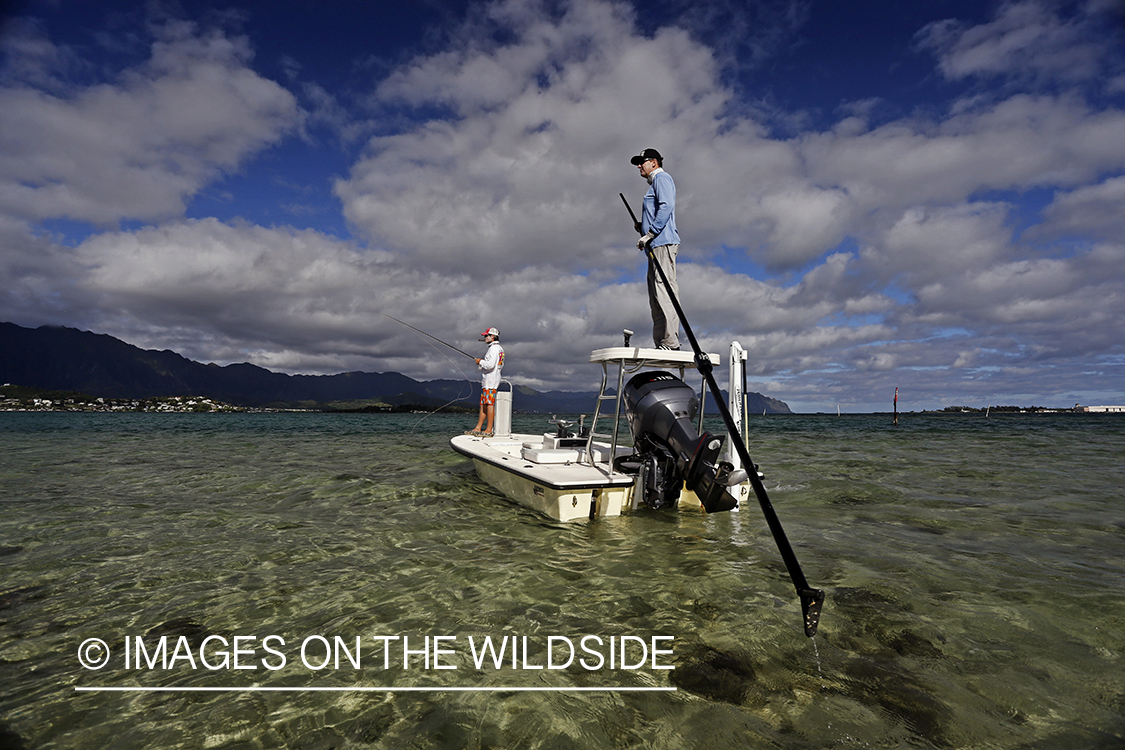 Saltwater flyfishermen fishing on flats boat, in Hawaii.