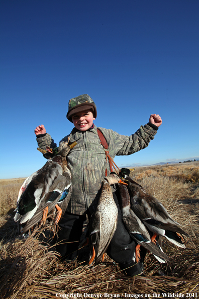 Child with bagged mallards. 