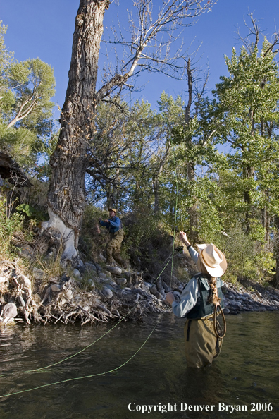 Woman flyfisher and flyfisherman undoing a snag.